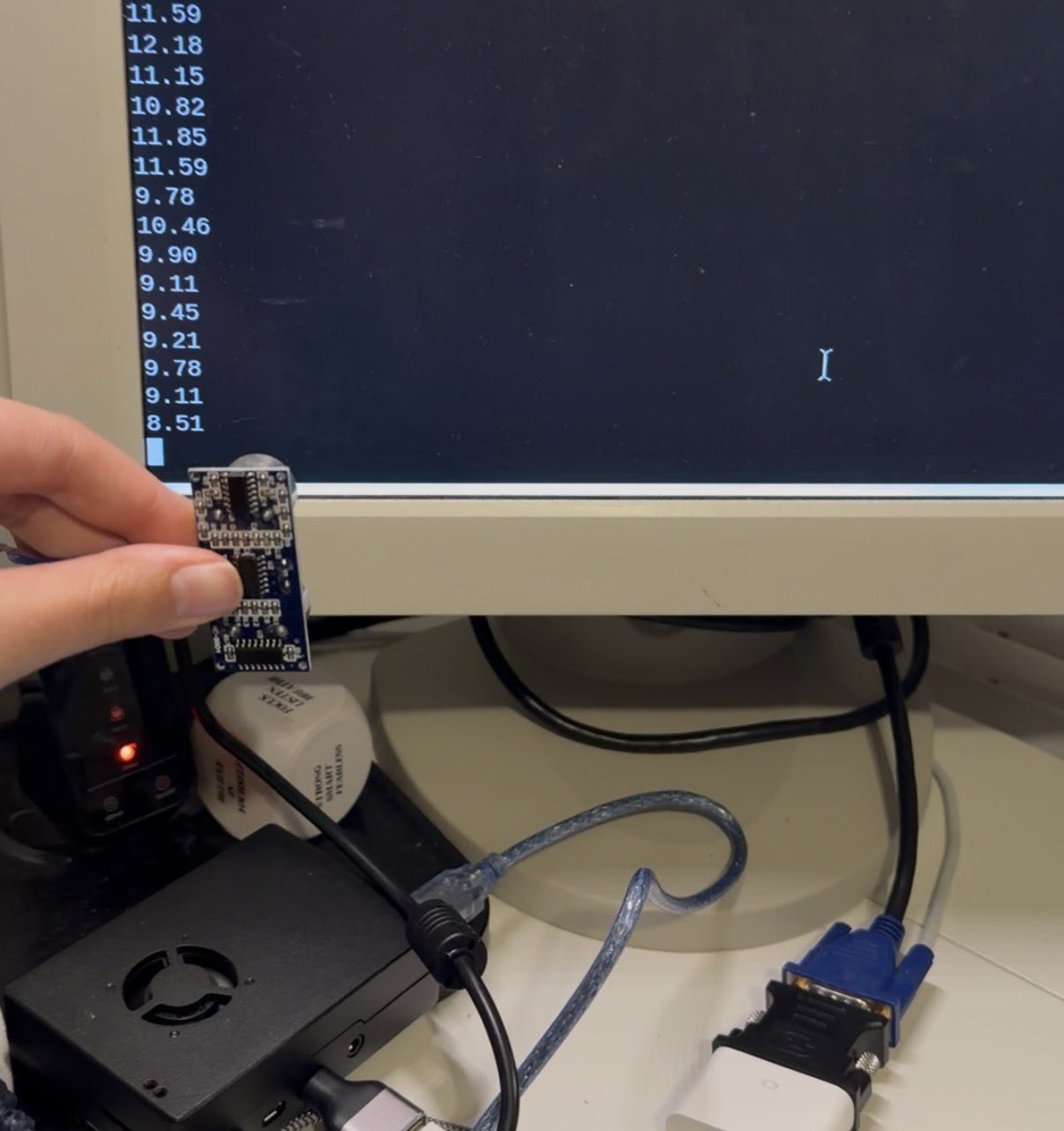 Holding the HC-SR04 sensor in front of a terminal printing distance readings